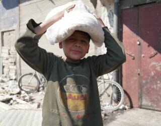 叙利亚阿勒波。孩子们与他们的父母一起排队，或者在上学前被派去单独领取面包。照片：世界粮食计划署/Hussam Al Saleh